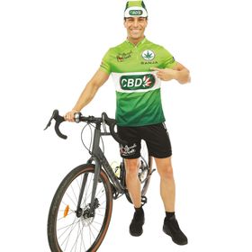 Mann im grünen Radfahrer-Kostüm mit Fahrrad, zeigt lachend auf sein Trikot.