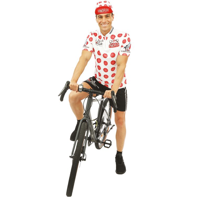 Mann im weißen, gepunkteten Radfahrer-Kostüm mit Mütze und Fahrrad.