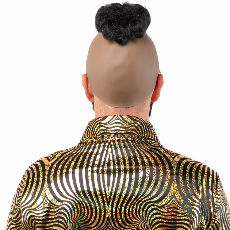 Designer Perücke Schwarz Hochfrisur Glamour Style mit Bart für Herren Kostüm-Zubehör Fasching Karneval Mottoparty JGA Ein Mann trägt eine schwarze Hochfrisur-Perücke mit integriertem Bart. Auf der Rückseite ist die beigefarbene Latexkappe sichtbar, die das Haarteil fixiert. Er trägt ein goldenes Hemd mit auffälligem Muster.