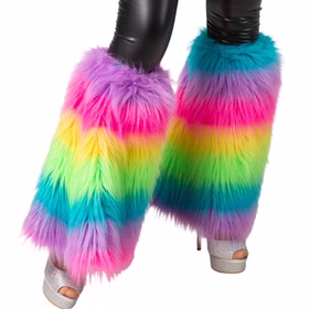Ein Paar bunte Plüsch-Stulpen in Regenbogenfarben, getragen über schwarzen Leggings und offenen Plateau-Schuhen. Der lange Flor der Stulpen reicht bis über die Knöchel.
