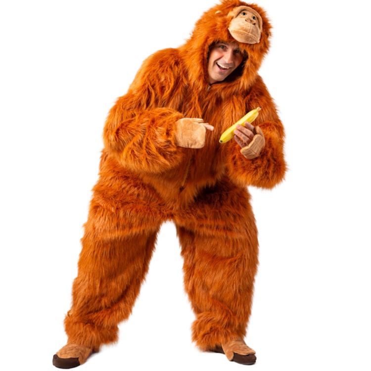 Affen Kostüm Orang Utan Koko Plüschkostüm für Erwachsene Person im flauschigen orangenen Orang-Utan-Kostüm hält eine Banane und lacht in die Kamera.