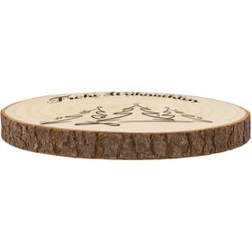 Große Baumscheibe mit Gravur, eingebettet in ein festliches Arrangement aus Tannenzweigen, goldenen Kugeln, Teelichtern und Kunstschnee, im Hintergrund warm leuchtende Bokeh-Lichter.