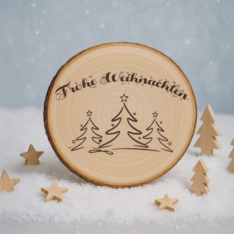 Große Baumscheibe mit Gravur, eingebettet in ein festliches Arrangement aus Tannenzweigen, goldenen Kugeln, Teelichtern und Kunstschnee, im Hintergrund warm leuchtende Bokeh-Lichter.