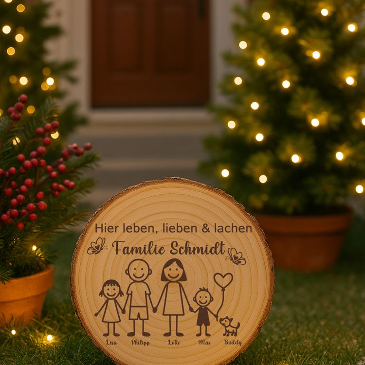 Personalisierte Familien-Baumscheibe auf einer Steintreppe vor der Haustür, umgeben von Topfpflanzen mit orangefarbenen Blüten.