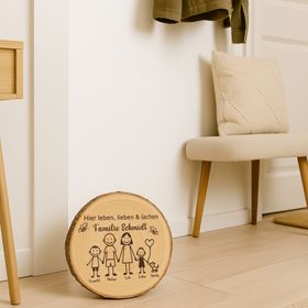 Die gravierte Baumscheibe steht auf einer Steintreppe, umgeben von Blumentöpfen, und dient als einladendes Willkommensschild vor der Haustür.