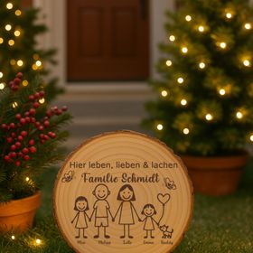 Die gravierte Baumscheibe steht auf einer Steintreppe, umgeben von Blumentöpfen, und dient als einladendes Willkommensschild vor der Haustür.