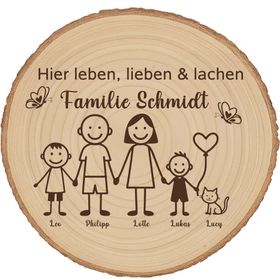 Personalisierte Holzscheibe mit Familienmotiv lehnt an einer Backsteinwand neben einer grünen Zimmerpflanze in einem natürlichen Wohnraumambiente.