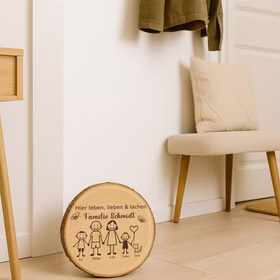 Baumscheibe 30 cm Familie Willkommensschild personalisiert mit zwei Jungen & Katze Zuhause Deko & Geschenk Eingangsbereich Geschenk für Familie und Freunde Einzug Herzlich Willkommen Holzscheibe personalisiert Runde Holz-Baumscheibe lehnt an einer Wand im Eingangsbereich neben einem Stuhl und Garderobe und dient als dekoratives Willkommensschild für die Familie.
