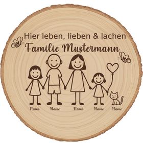Personalisierte Holzscheibe mit Familienmotiv lehnt an einer Backsteinwand neben einer grünen Zimmerpflanze in einem natürlichen Wohnraumambiente.