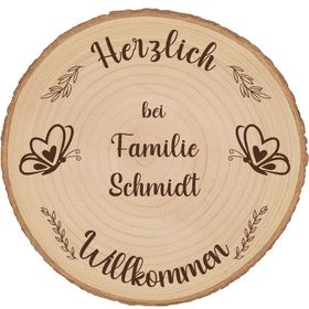Personalisierte Baumscheibe als Willkommensschild im sommerlichen Blumenbeet vor einem Hauseingang, mit Gravur und Schmetterlingsmotiv.