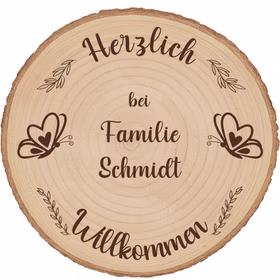 Nahaufnahme der Holzmaserung auf einer gravierten Baumscheibe mit Schmetterlingsmotiv und Familiennamen