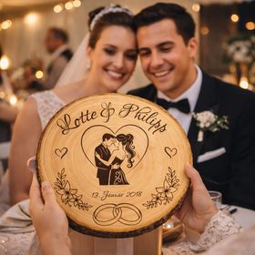 Personalisierte Holz-Baumscheibe als Hochzeitsgeschenk, dekoriert mit Kerzen, Rosen und Spitze auf einer festlichen Tischdekoration.