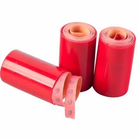 Drei rote Papierrollen mit Zündplättchen, eine Rolle leicht abgewickelt und sichtbar mit einzelnen Schussfeldern.
