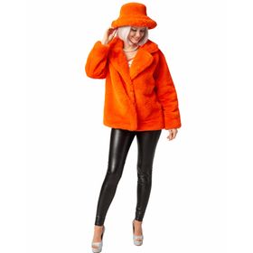 Frau trägt eine orangefarbene flauschige Plüschjacke mit passendem Plüschhut, schwarze Kunstlederhose und silberne High Heels, Frontalansicht auf weißem Hintergrund.