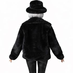 Dame trägt schwarze Plüschjacke und schwarzen Plüschhut im Vintage-Stil, kombiniert mit schwarzer Hose und silbernem Top.