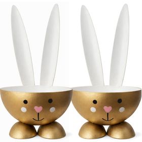 Zwei goldfarbene Eierbecher im Osterhasen-Design aus Metall nebeneinander stehend mit weißer Innenseite, Hasenohren und liebevoll gestaltetem Gesicht.