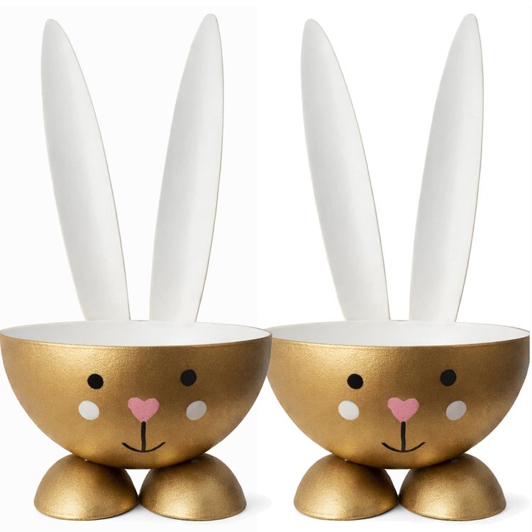 2 Eierbecher Hase Gold aus Metall Osterhase 10 cm gedeckter Tisch Ostern Zwei goldfarbene Eierbecher im Osterhasen-Design aus Metall nebeneinander stehend mit weißer Innenseite, Hasenohren und liebevoll gestaltetem Gesicht.