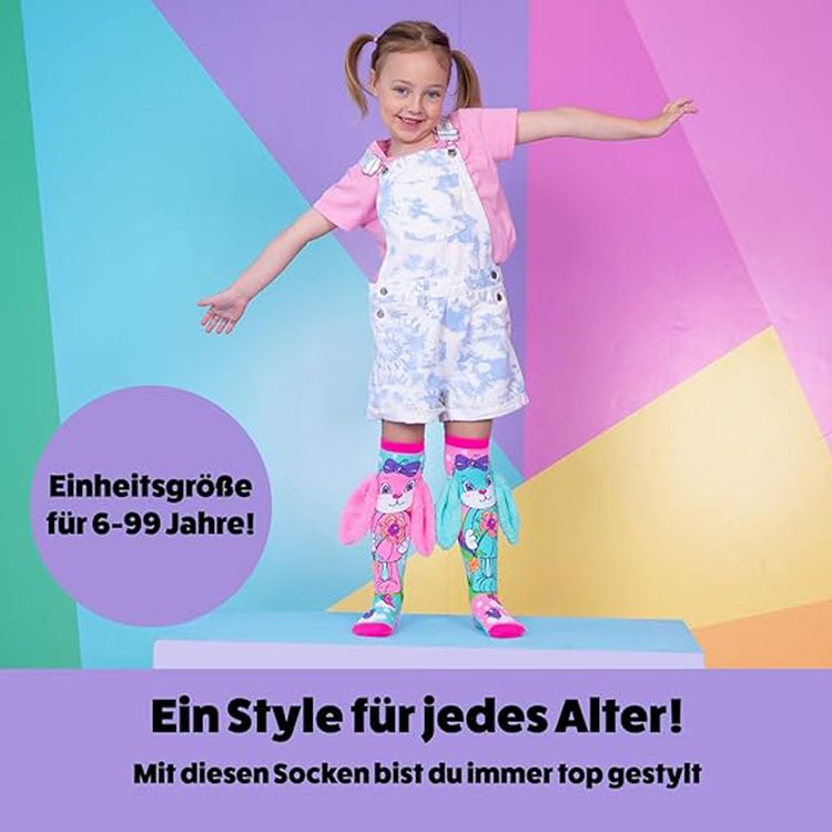 Kind trägt bunte Kniestrümpfe mit großem Hasenmotiv in Pink und Türkis. Die Socken haben flauschige 3D-Ohren und zeigen Blumen-, Vogel- und Wolkenmotive.