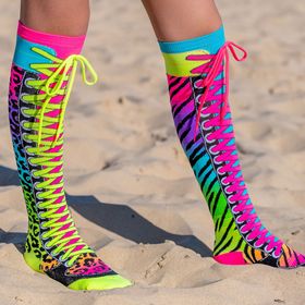 Knallbunte Neon-Kniestrümpfe im Safari-Design mit Zebra- und Leopardenmuster sowie aufgenähten Schnürsenkeln in Pink und Neon-Grün, seitlich am Bein getragen.