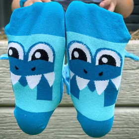 Lustige Socken Hai Henri mit Taucherbrille & 3D-Flosse für Kinder & Erwachsene Tiersocken Spaßsocken Kindersocken Fun-Socken Hai-Socken Shark Kostüm-Zubehör Geburtstag Mottoparty Fasching Karneval Unterseite der Socken mit großem Hai-Gesicht und weißen Zähnen im Comic-Design.