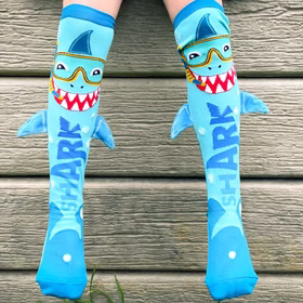 Lustige Socken Hai Henri mit Taucherbrille & 3D-Flosse für Kinder & Erwachsene Tiersocken Spaßsocken Kindersocken Fun-Socken Hai-Socken Shark Kostüm-Zubehör Geburtstag Mottoparty Fasching Karneval Blaue Kniestrümpfe mit lachendem Hai-Gesicht und 3D-Flossen, getragen im Freien vor Holzstufen.