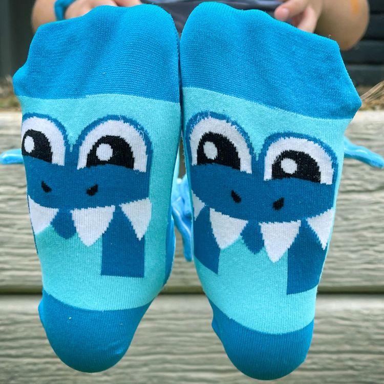 Blaue Kniestrümpfe mit fröhlichem Hai-Motiv, Taucherbrille und seitlich angenähten 3D-Flossen, Vorderansicht beider Socken.
