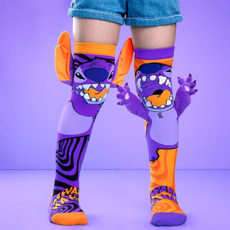 Lustige Stitch Socken Stitchzilla Halloween mit 3D-Ohren für Kinder & Erwachsene Lila-orange Kniestrümpfe mit Stitch Halloween Motiv und seitlich angenähten 3D-Ohren, getragen mit hochgekrempelter Jeansshorts.