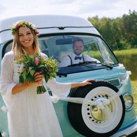 Detailansicht der weißen Hochzeitsgirlande mit Rosenblüten entlang der Motorhaube eines Fahrzeugs.