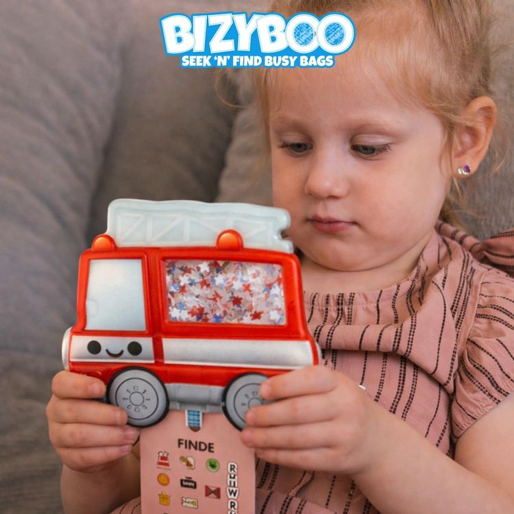 Feuerwehr Sensorik Reise-Spielzeug mir Perlen & versteckten Objekten ab 2 Jahren Sensorik-Spielzeug in Form eines roten Feuerwehrautos mit transparentem Fenster, gefüllt mit kleinen Perlen und versteckten Symbolen. Am unteren Rand hängt eine Suchkarte mit verschiedenen Feuerwehr-Motiven und Buchstaben.