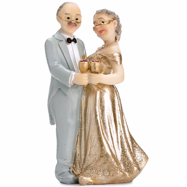 Tortenaufsatz Goldene Hochzeit Ehepaar Jubiläum Tisch-Deko Party-Zubehör Party-Deko Dekoration 50 Ehejahre Jubiläum Figur eines älteren Ehepaares als Tortenaufsatz zur goldenen Hochzeit, Mann im hellen Anzug und Frau im goldenen Kleid stoßen mit Sektgläsern an.