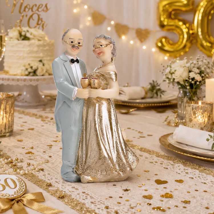 Tortenaufsatz Goldene Hochzeit Ehepaar Jubiläum Tisch-Deko Party-Zubehör Party-Deko Dekoration 50 Ehejahre Jubiläum Dekorative Tischszene zur goldenen Hochzeit mit Tortenaufsatz eines älteren Ehepaares, goldenen Accessoires, Kerzen und festlicher Dekoration.
