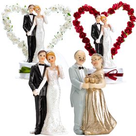 Tortenaufsatz Hochzeitspaar in Weiß mit Herz aus Rosen, Braut im Kleid und Bräutigam im Anzug auf dekorativem Sockel mit grünem Band.