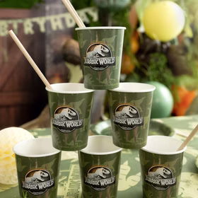 Mehrere Jurassic World Becher gestapelt mit Strohhalmen auf Party-Tisch.
