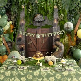 Jurassic World XXL Party-Set mit Banner, Tischdecke, Tellern, Bechern, Ballons, Servietten und Geschenktüten als Gesamtübersicht.