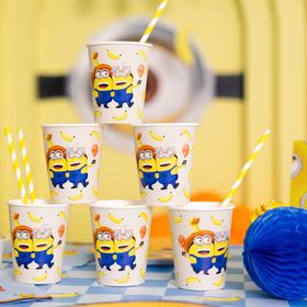 Minions Partybecher 6 Stück Becherturm Sechs Minions Partybecher mit Bananen-Motiv dekorativ als Pyramide auf einer gelb-blauen Geburtstagstafel angeordnet.