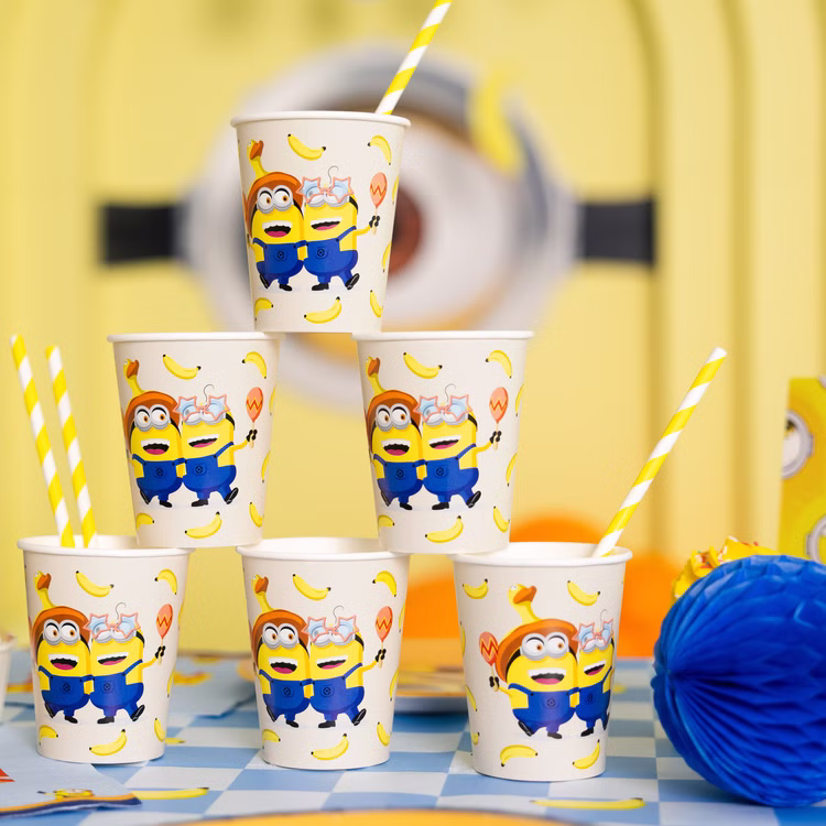 Minions Partybecher 6 Stück Becherturm Sechs Minions Partybecher mit Bananen-Motiv dekorativ als Pyramide auf einer gelb-blauen Geburtstagstafel angeordnet.
