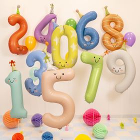 Gelber Folienballon in Form der Zahl 0 mit Sternenmuster, Gesicht und Partyhut vor hellem Hintergrund.