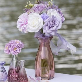 Grüne Glasvase Corolle mit geschwungener Form und dekorativ gewelltem Rand auf hellem Hintergrund.