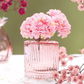 Rosa Mini-Glasvase „Helios“ mit zarten rosafarbenen Kunstblüten als elegante Tischdeko für romantische Anlässe.