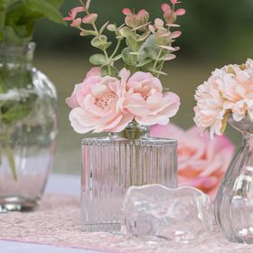 Bunt gemischtes Mini-Glasvasen-Set mit kleinen Blumenarrangements als stilvolle Tischdeko im romantischen Ambiente.