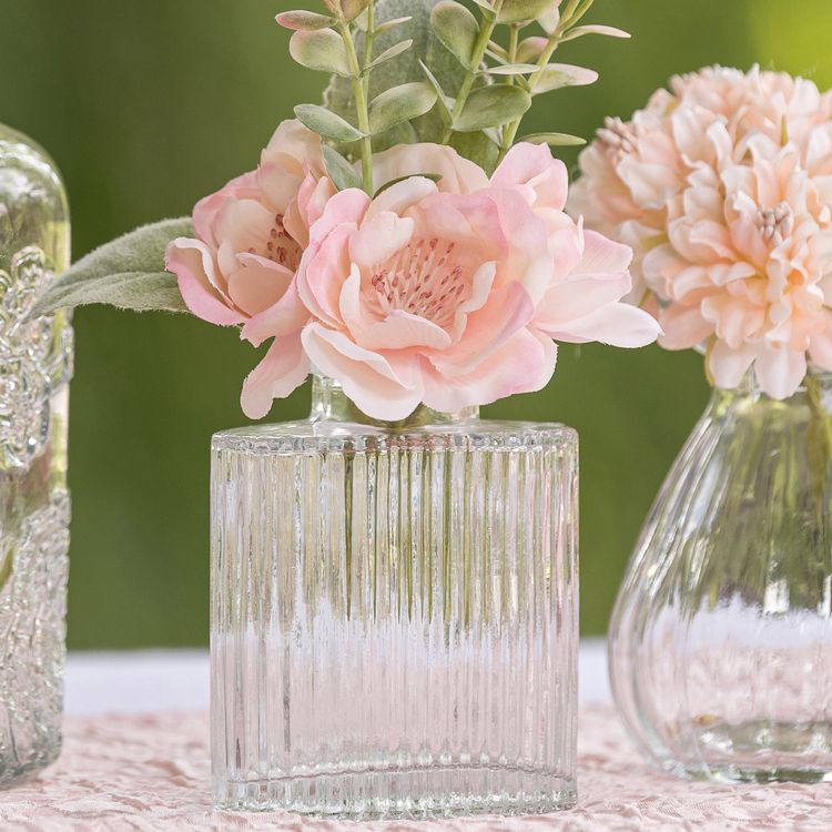 Bunt gemischtes Mini-Glasvasen-Set mit kleinen Blumenarrangements als stilvolle Tischdeko im romantischen Ambiente.