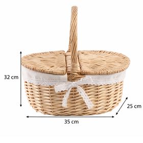Geflochtener Picknickkorb aus Weide mit geöffnetem Deckel und hellem Stoffeinsatz mit Spitze.