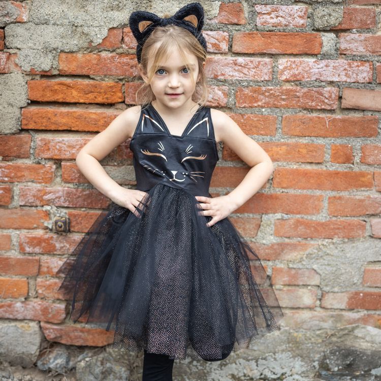 Schwarzes Katzenkostüm für Kinder mit Tüllrock und Haarreif mit Katzenohren vor weißem Hintergrund.