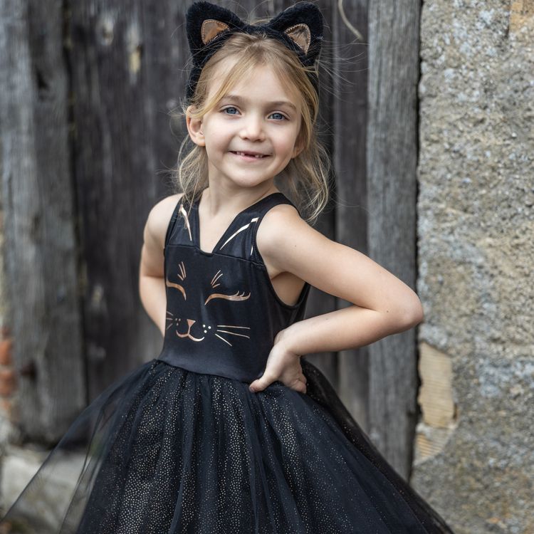 Schwarzes Katzenkostüm für Kinder mit Tüllrock und Haarreif mit Katzenohren vor weißem Hintergrund.