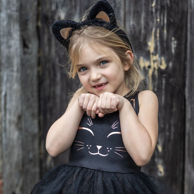 Schwarzes Katzenkostüm für Kinder mit Tüllrock und Haarreif mit Katzenohren vor weißem Hintergrund.