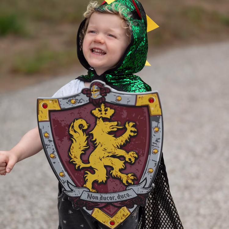 Ritterschild für Kinder EVA Schaumstoff mit Löwenwappen weich Mittelalter Kostüm-Zubehör Schutzschild Fasching Karneval Mottoparty Rollenspiel Kinderfasching Spielzeug-Schild Detailansicht eines mittelalterlichen Spielzeug-Schilds mit Löwenmotiv aus Schaumstoff in Kinderhand.