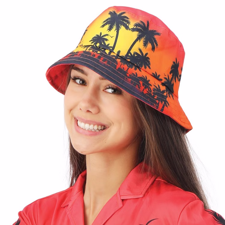 Fischerhut Hawaii Tropical Palmen Sunset Bucket Hat Festival für Erwachsene Kostüm-Zubehör Fasching Karneval Mottoparty JGA Beachparty Sommerurlaub Frau trägt Hawaii Fischerhut mit Palmenmotiv im Sonnenuntergangsdesign.