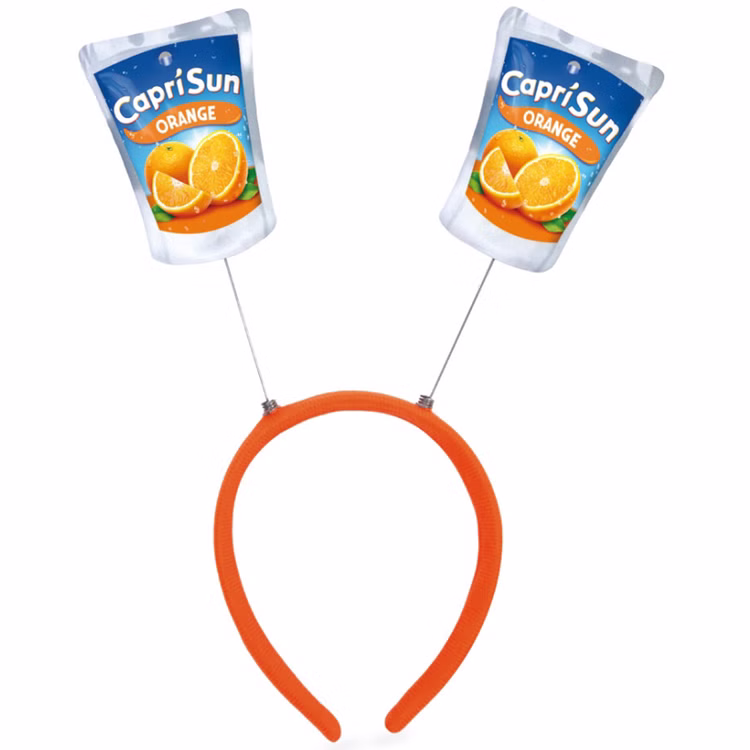 Capri Sun Orange Haarreif Produktansicht Oranger Capri-Sun® Haarreif mit zwei beweglich befestigten Trinkpäckchen-Motiven der Sorte Orange auf weißem Hintergrund.