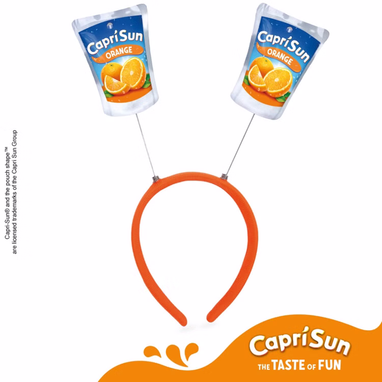Capri Sun Orange Haarreif Lizenzartikel Lizenzierter Capri-Sun® Orange Haarreif mit zwei Trinkpäckchen-Motiven, Capri Sun Logo und Markenhinweis auf weißem Hintergrund.