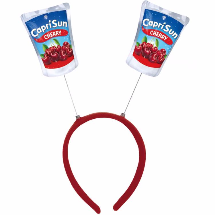 Capri Sun Cherry Haarreif Produktansicht Roter Capri-Sun® Cherry Haarreif mit zwei beweglich befestigten Trinkpäckchen-Motiven auf weißem Hintergrund.